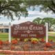 A charming view of Anna Texas with a mix of historic buildings, modern homes, and open fields under a bright Texas sky.