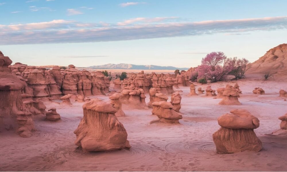 Panoramic view of Goblin Valley State Park showcasing its iconic hoodoos and unique desert terrain under a clear blue sky.