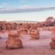 Panoramic view of Goblin Valley State Park showcasing its iconic hoodoos and unique desert terrain under a clear blue sky.