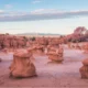 Panoramic view of Goblin Valley State Park showcasing its iconic hoodoos and unique desert terrain under a clear blue sky.