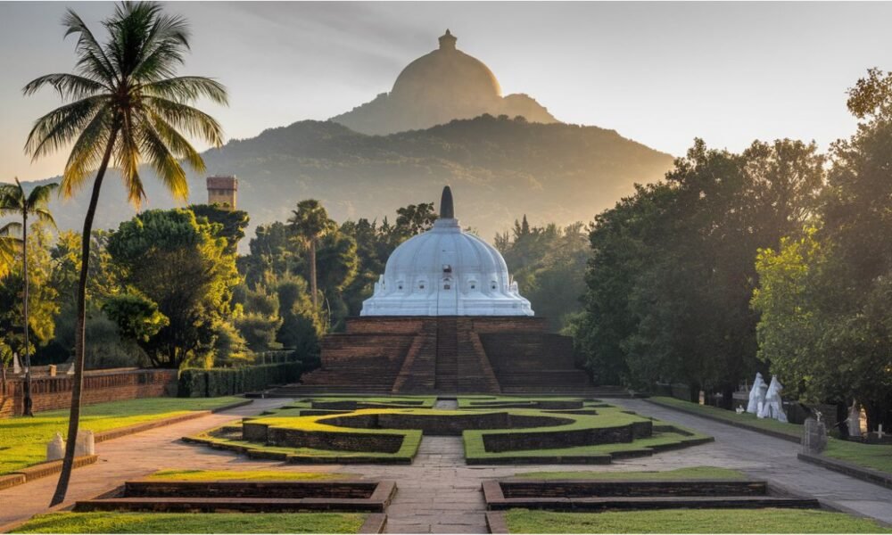 A serene view of Lumbini with temples, stupas, and the Ashokan Pillar under a vibrant sky.